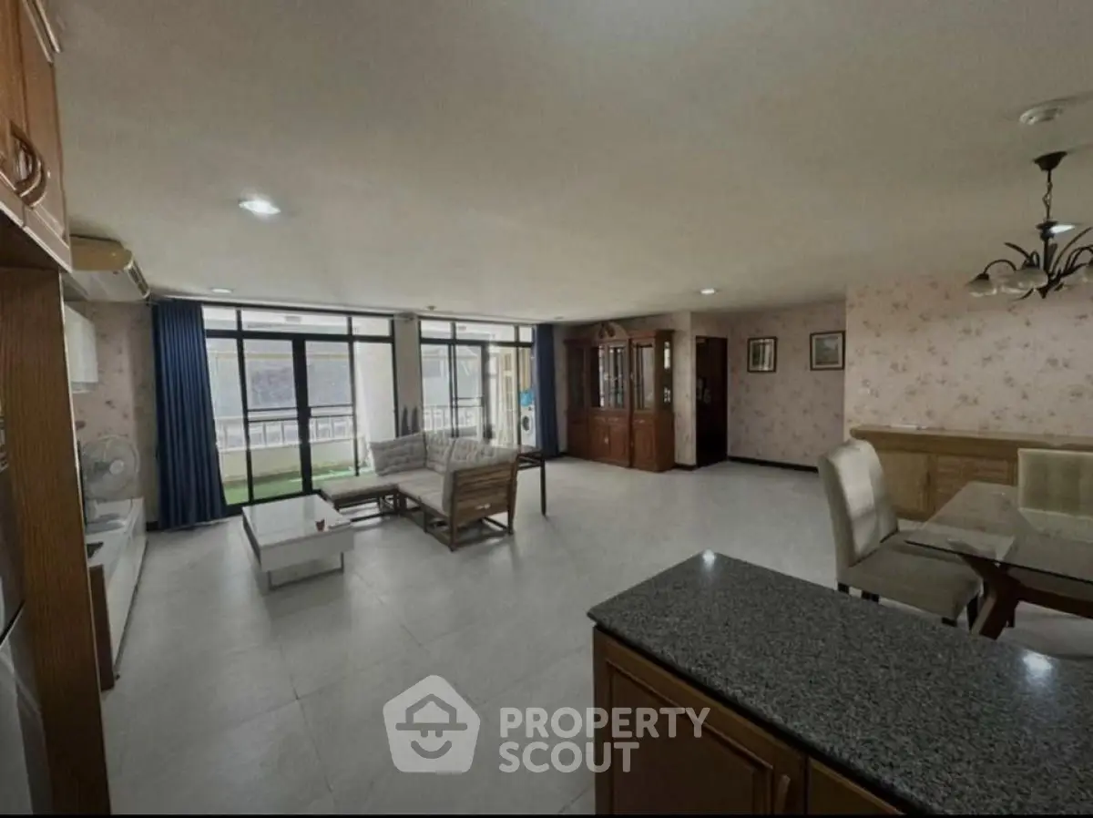 Spacious open-plan living room with modern furniture and large windows.