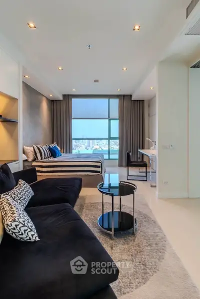 Modern studio apartment with stylish decor and city view, featuring a cozy living area and workspace.