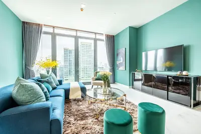Luxurious living room with stunning city view, elegant decor, and modern furnishings in a high-rise apartment.