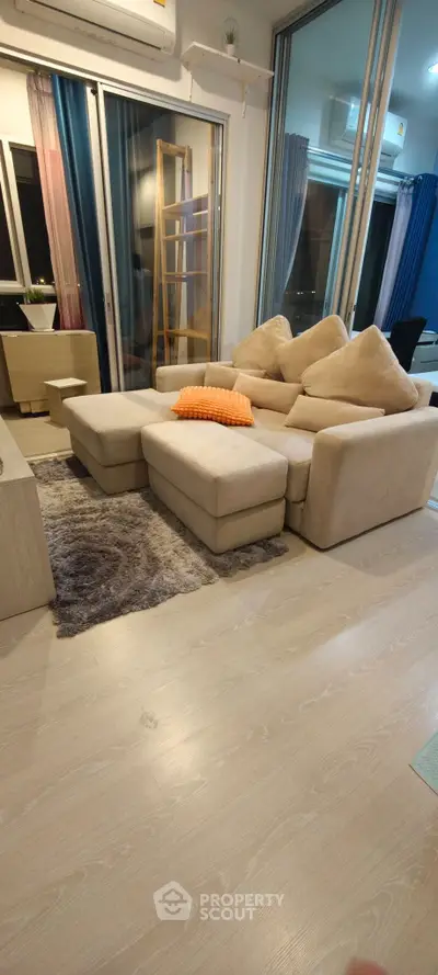Modern living room with cozy beige sofa and stylish decor in a contemporary apartment.