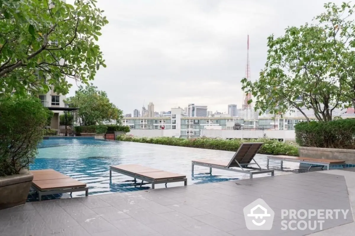 Luxurious rooftop pool with stunning city skyline views and relaxing lounge chairs.