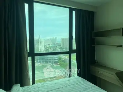 Modern bedroom with large window offering city view and natural light