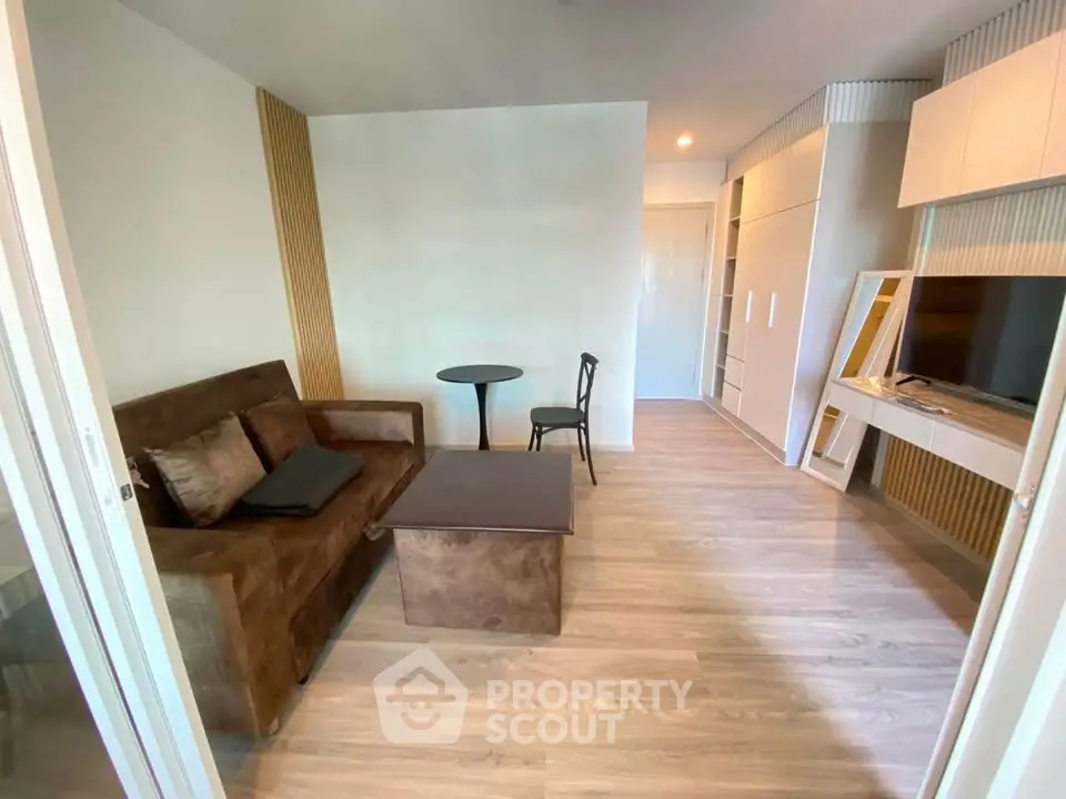 Modern living room with sleek furniture and wooden flooring in a stylish apartment.