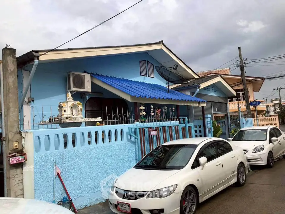 Charming blue house with modern design and ample parking space in a serene neighborhood.