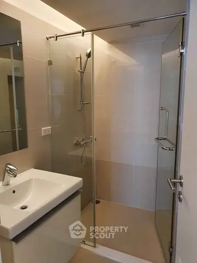 Modern bathroom with glass shower enclosure and sleek fixtures