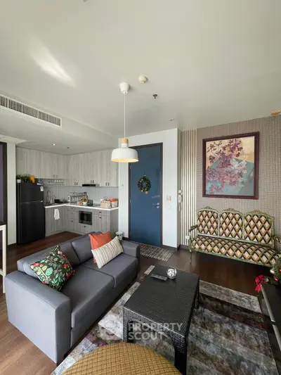 Stylish modern living room with open kitchen, featuring cozy seating and contemporary decor.