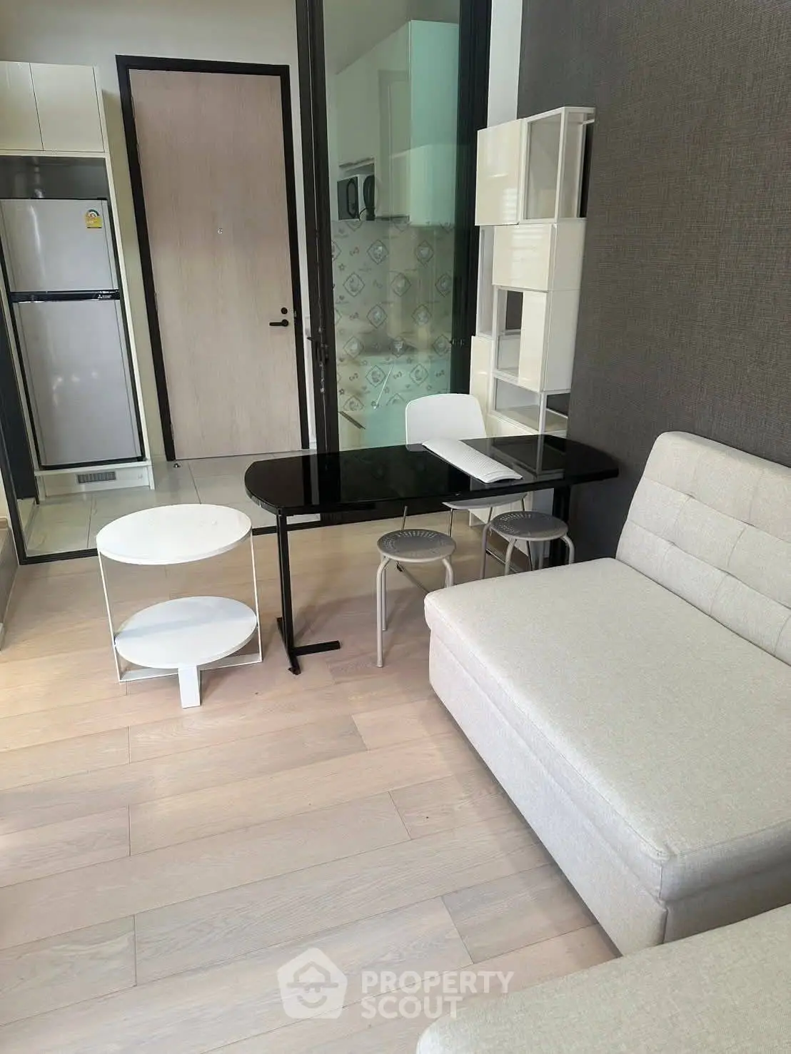 Modern living room with sleek furniture and open kitchen layout in a stylish apartment.