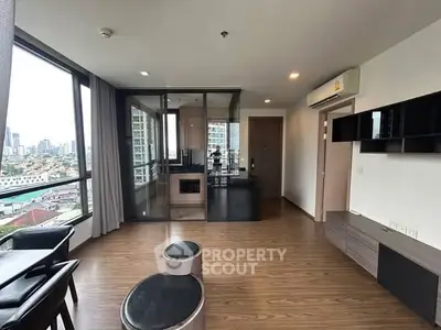 Modern living room with city view, featuring sleek furniture and large windows.