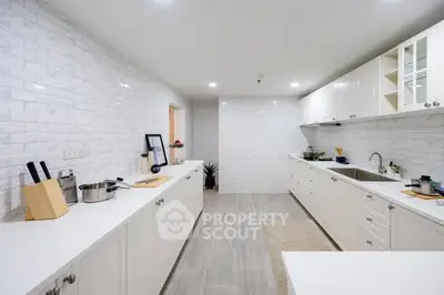 Spacious modern kitchen with sleek white cabinetry and ample counter space.