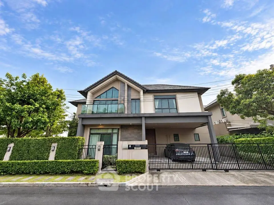 Stunning modern two-story house with lush greenery and spacious driveway.