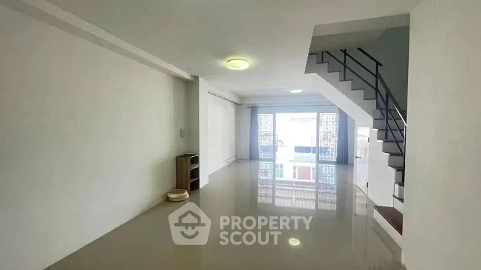 Spacious modern living room with sleek staircase and large windows