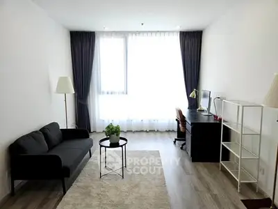 Modern living room with sleek furniture and large window, perfect for urban living.