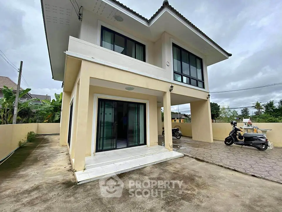 Modern two-story house with spacious driveway and large windows, perfect for family living.