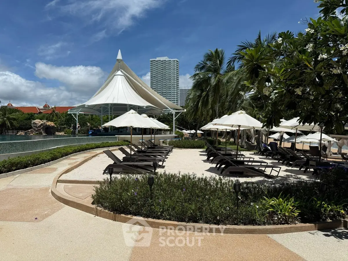 Luxurious poolside area with sun loungers and tropical landscaping in a high-end resort.