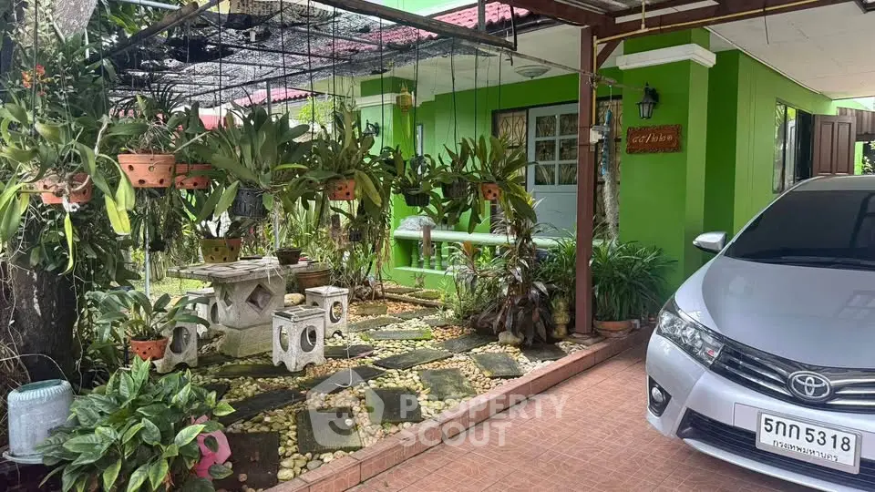 Charming green home with lush garden and carport, perfect for nature lovers.