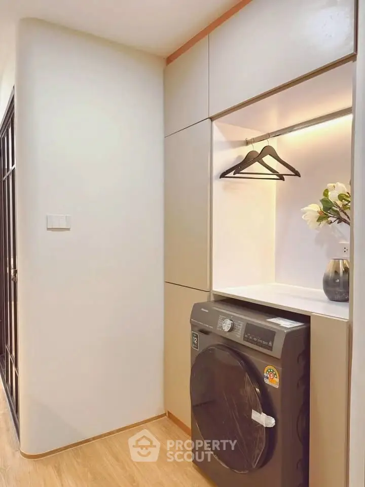 Modern laundry area with built-in washing machine and elegant storage space.