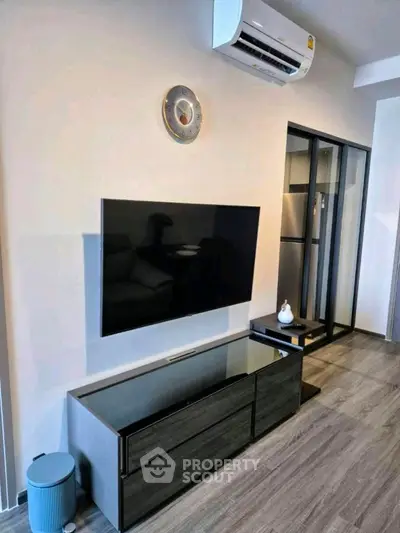 Modern living room with sleek TV setup and air conditioning unit.