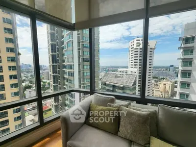 Stunning corner unit with panoramic city views from a cozy living room, featuring large windows and modern decor.