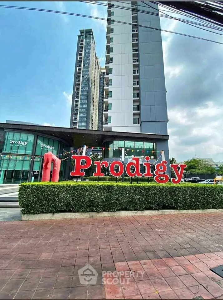 Modern high-rise building with sleek design and prominent Prodigy signage in urban setting.