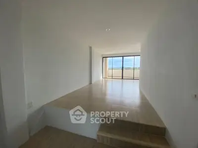 Spacious minimalist room with large windows and scenic view