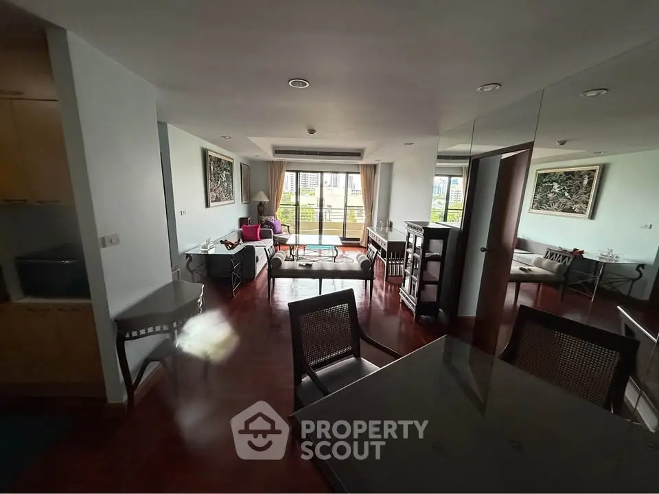 Spacious living room with elegant decor and large windows offering a stunning city view.