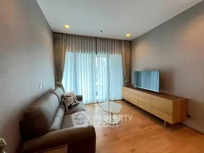 Modern living room with sleek furniture and large window for natural light.