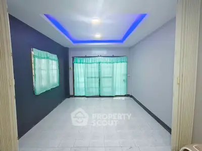Spacious living room with modern lighting and large windows for natural light.