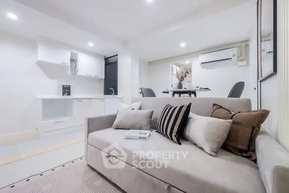 Modern living room with stylish sofa and open kitchen layout, perfect for contemporary living.