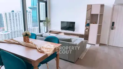Modern living room with city view, stylish furniture, and natural light in high-rise apartment.