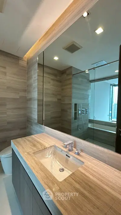 Luxurious modern bathroom with elegant wood paneling and sleek fixtures, perfect for a serene retreat.