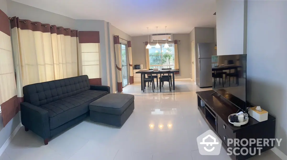 Spacious living room with gleaming tiled floors, modern furniture, and ample natural light, perfect for entertaining and relaxation.