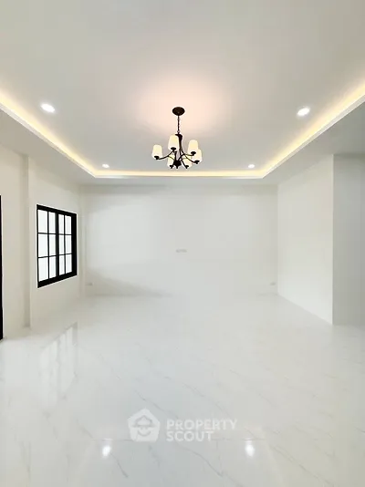 Spacious modern living room with elegant chandelier and large windows