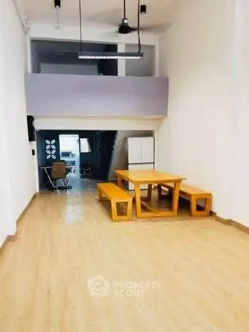 Spacious open-plan living area with wooden flooring and modern dining set.