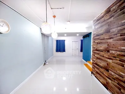 Spacious modern living room with stylish wood accent wall and elegant lighting.