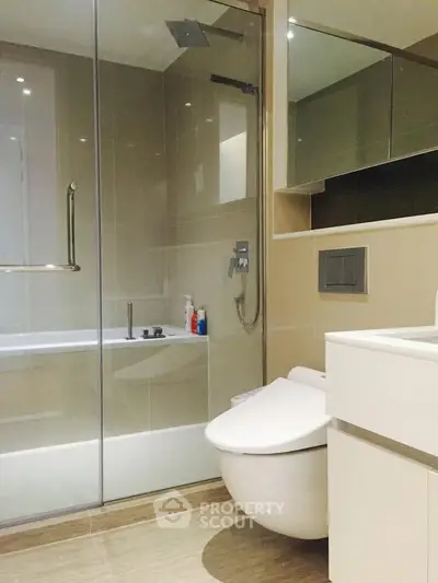 Modern bathroom with glass shower and sleek fixtures in contemporary apartment.