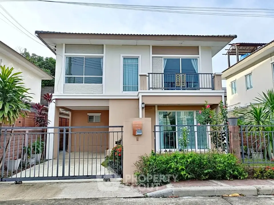 Modern two-story house with gated entrance and lush greenery