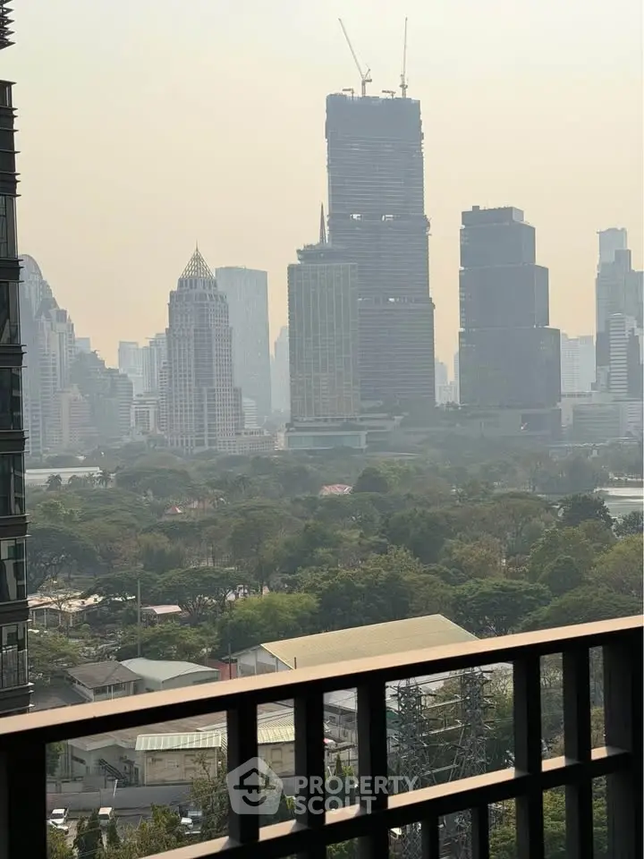 Stunning cityscape view from a high-rise balcony overlooking lush greenery and skyscrapers.