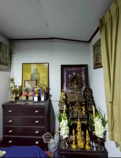 Cozy room corner with spiritual decor and wooden furniture, perfect for meditation and relaxation.