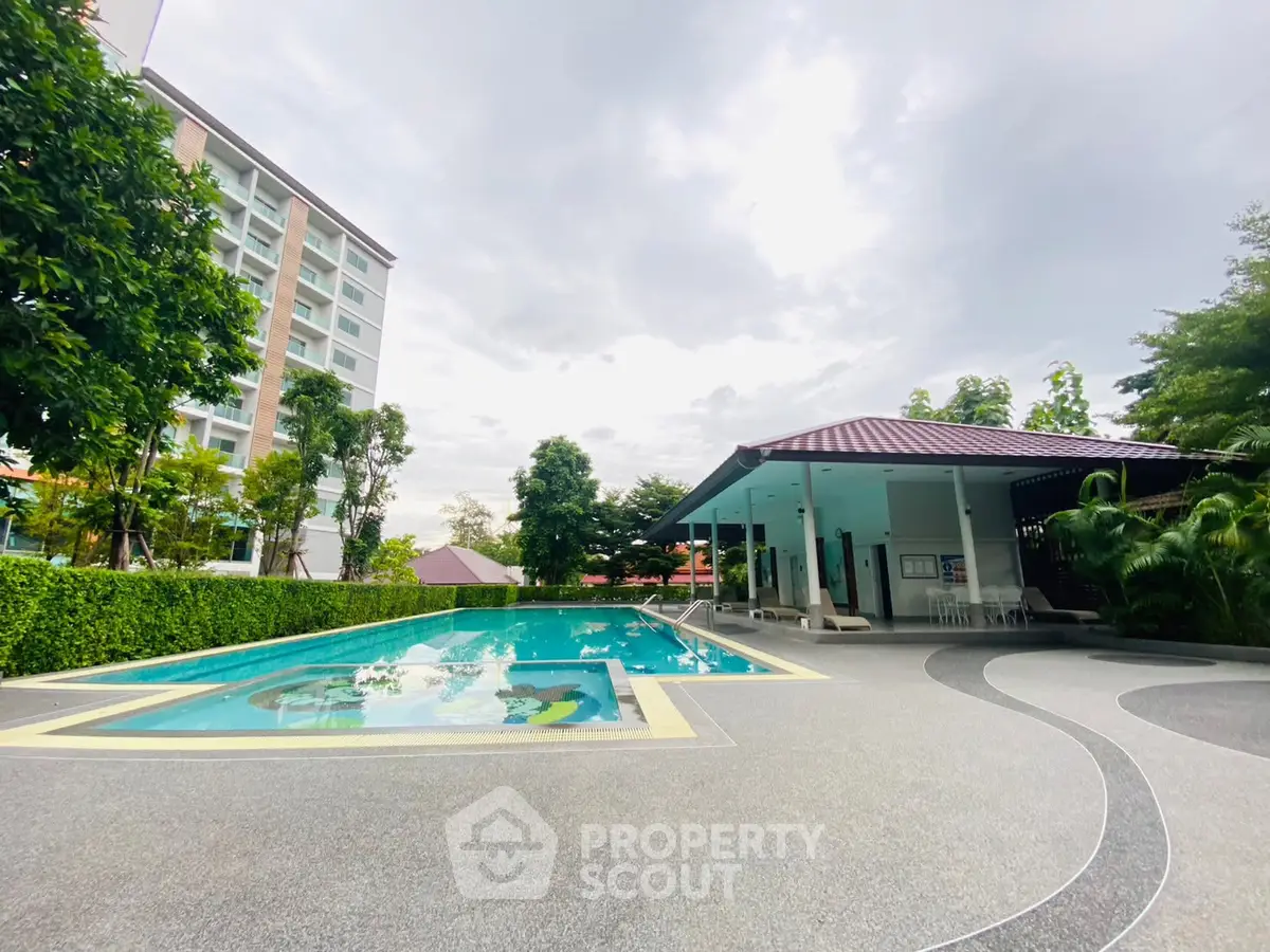 Luxurious outdoor pool area with modern amenities and lush greenery, perfect for relaxation and leisure.