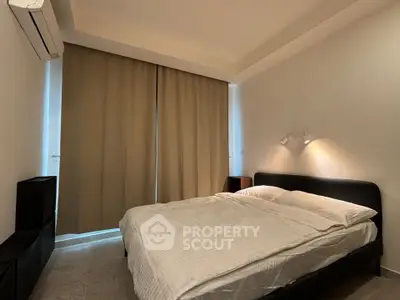 Cozy bedroom with modern design and ambient lighting, featuring a comfortable bed and elegant curtains.