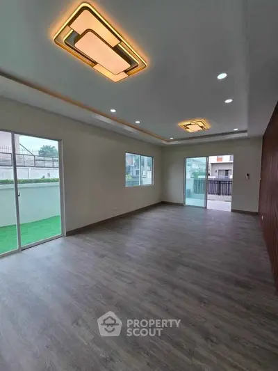 Spacious modern living room with stylish ceiling lights and large windows for natural light.