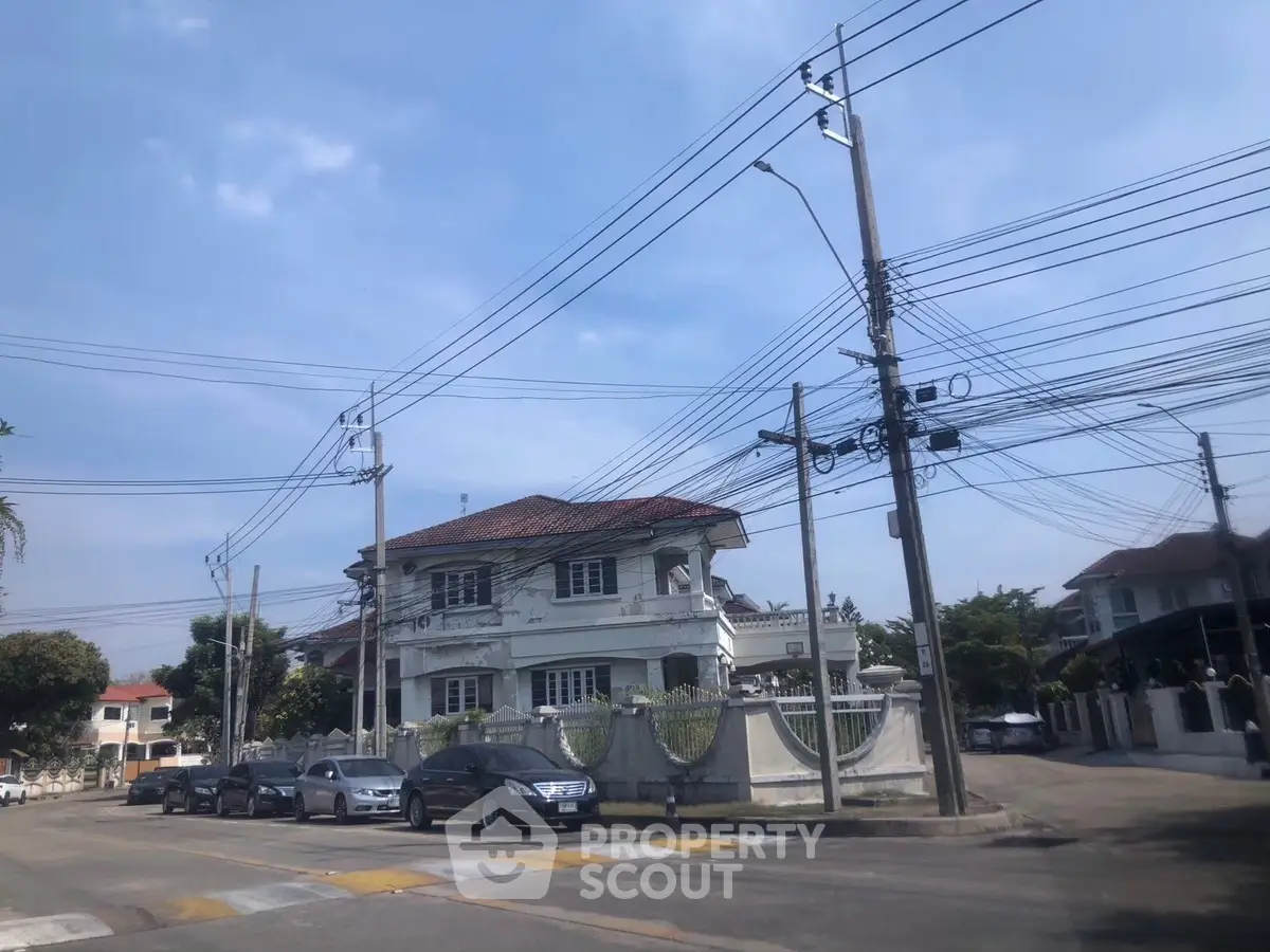 Charming two-story house with classic architecture on a sunny street corner.