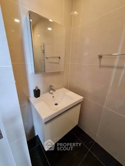 Modern bathroom with sleek sink and mirrored cabinet in a stylish apartment.
