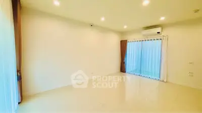 Spacious empty living room with large windows and air conditioning, perfect for customization.
