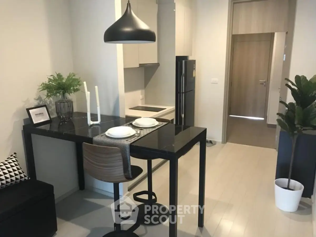 Modern kitchen with sleek black dining table and stylish pendant light