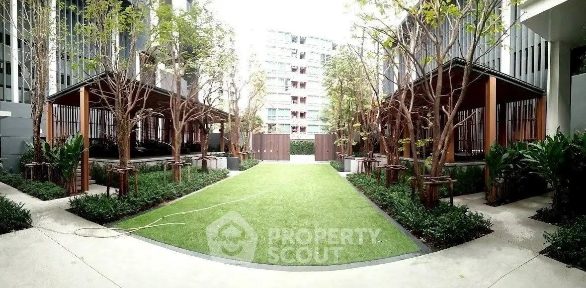 Modern apartment complex with landscaped garden and seating areas.