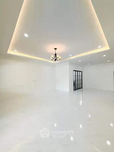 Spacious modern living room with elegant lighting and glossy white flooring