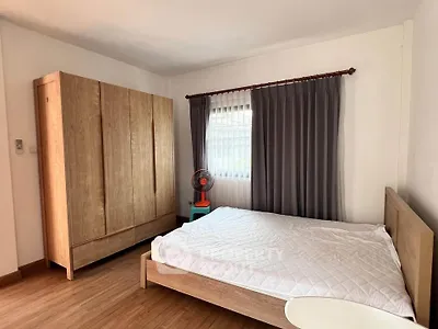 Spacious bedroom with wooden furniture and natural light