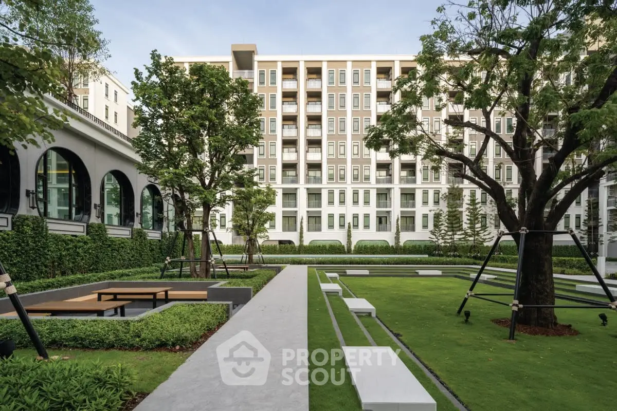 Modern apartment building with lush landscaped garden and seating area