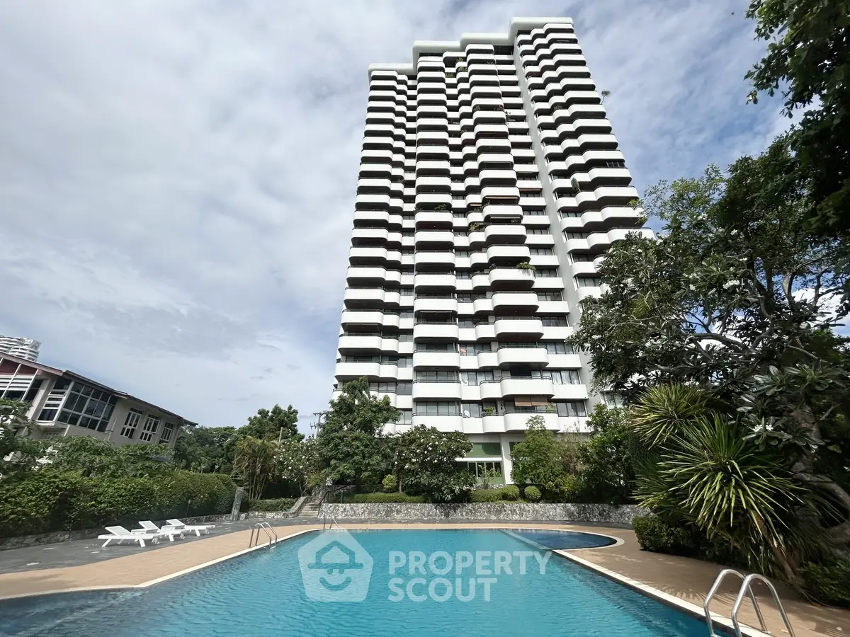 Luxurious high-rise building with a stunning pool and lush greenery, perfect for modern living.